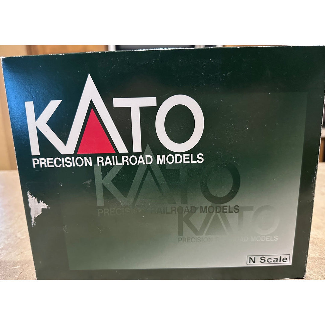 A box for Kato Precision Railroad Models N Scale, featuring a dark green and black design with white and red branding, photographed on a wooden surface.